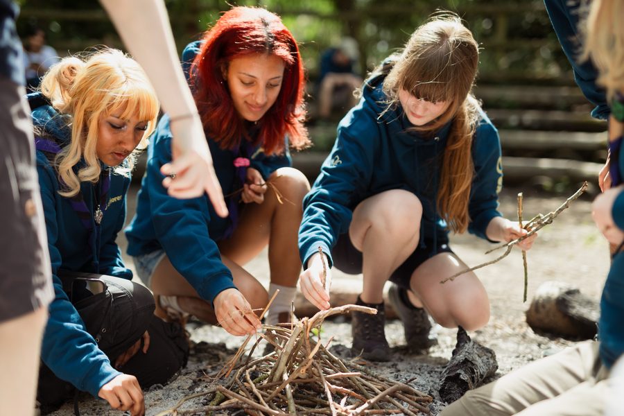 A group of Explorer Scouts building a campfire together