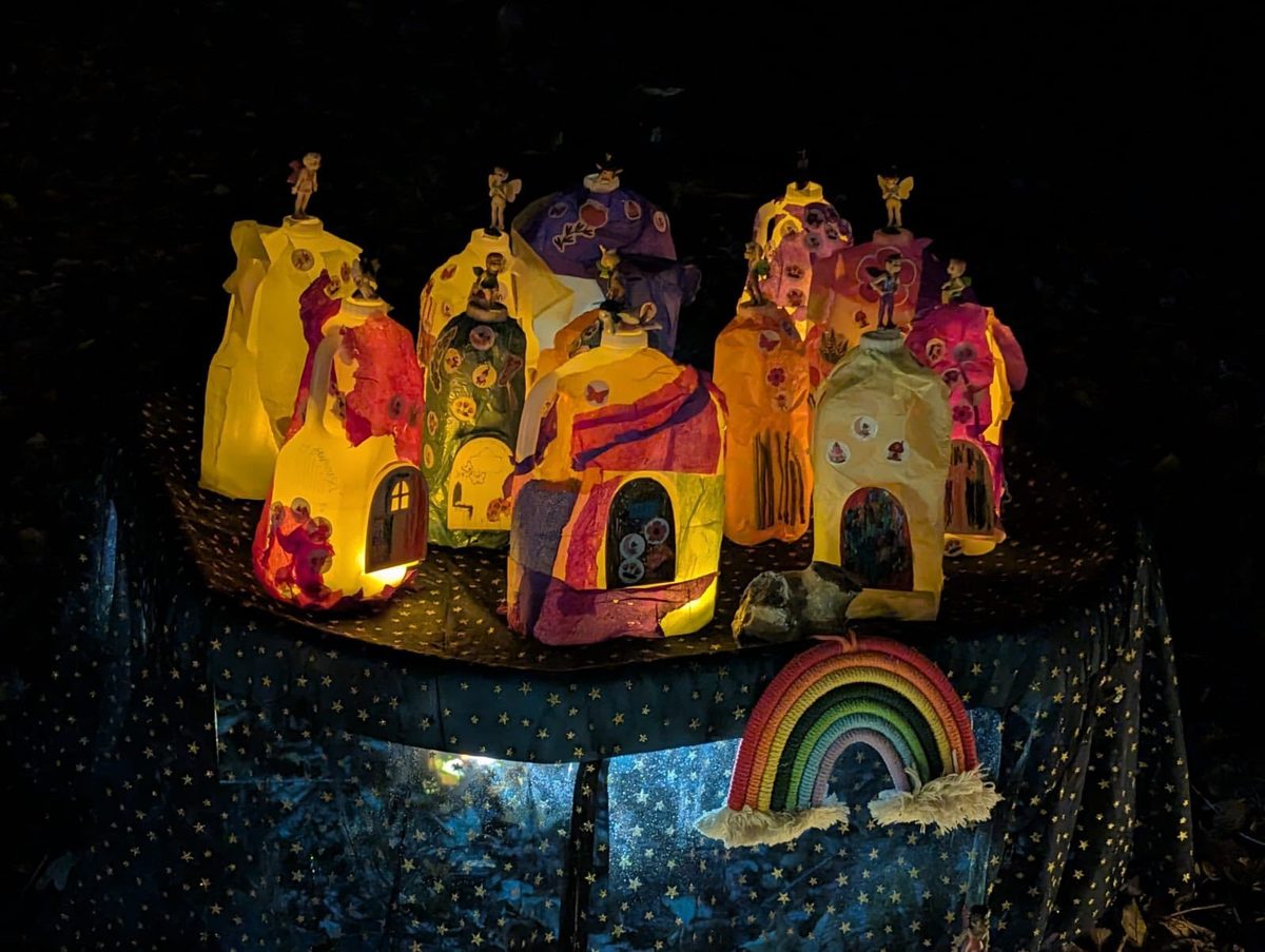 A row of illuminated fairy-village lanterns made by young people at the Glow Walk