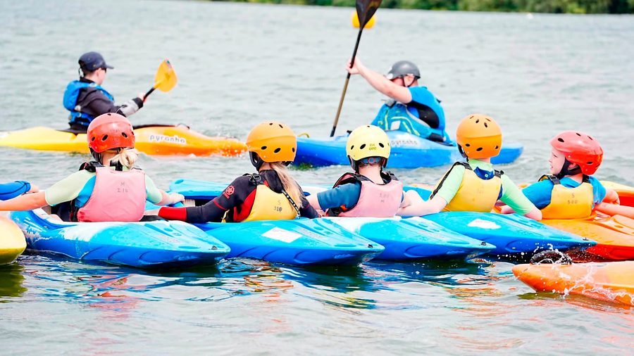 Young people kayaking in a line on Stewartby Lake during the Water Activity Days