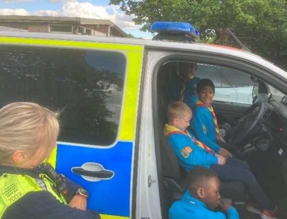 Harlington Scouts sitting inside a police van, talking with an officer