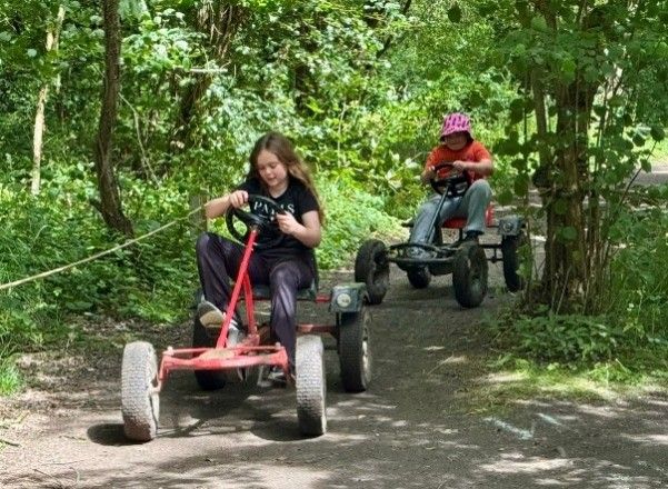 Harlington Scouts racing go-karts along a woodland trail