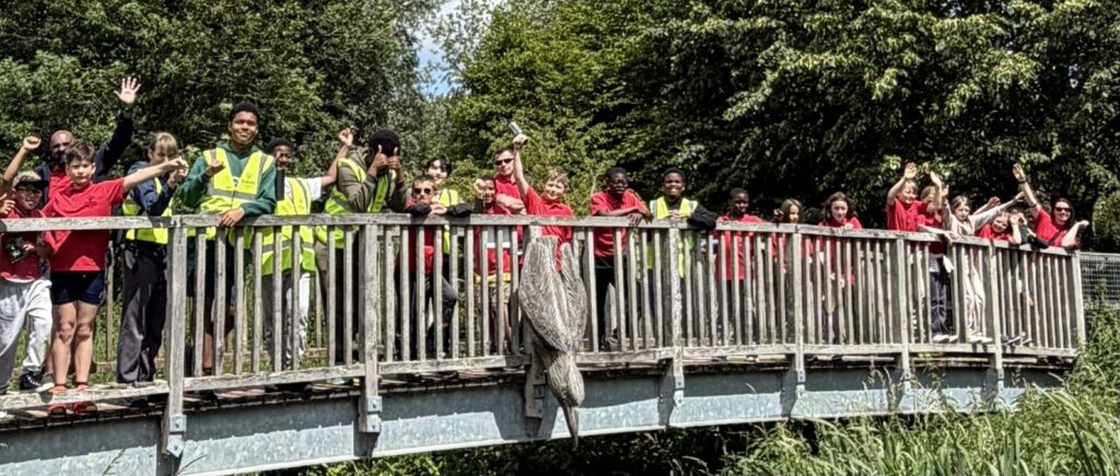St Joseph's Scouts and Explorers waving from a bridge on a district trip